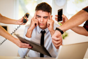 Man overwhelmed by distractions at work.