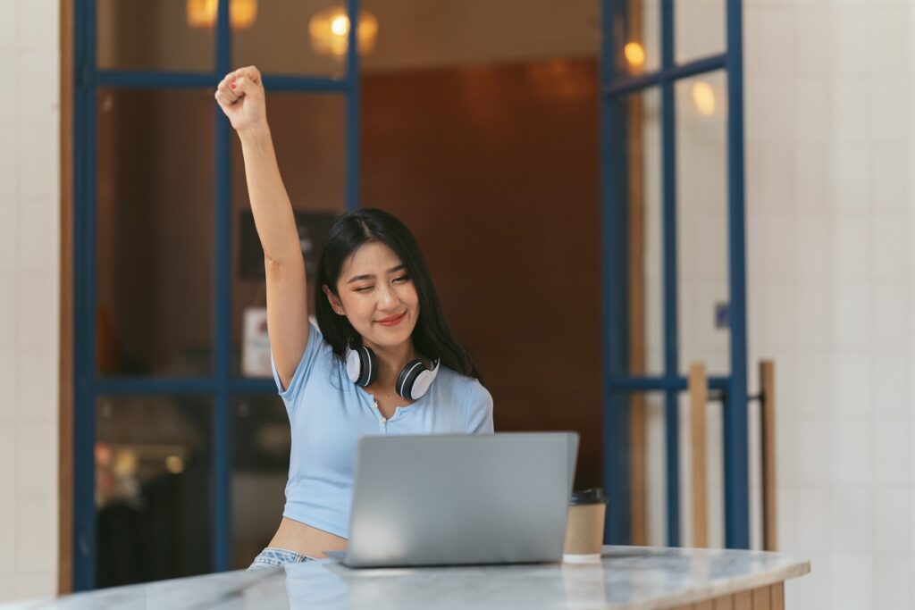 Woman celebrating resilience with laptop