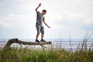 Man balancing on a log outdoors