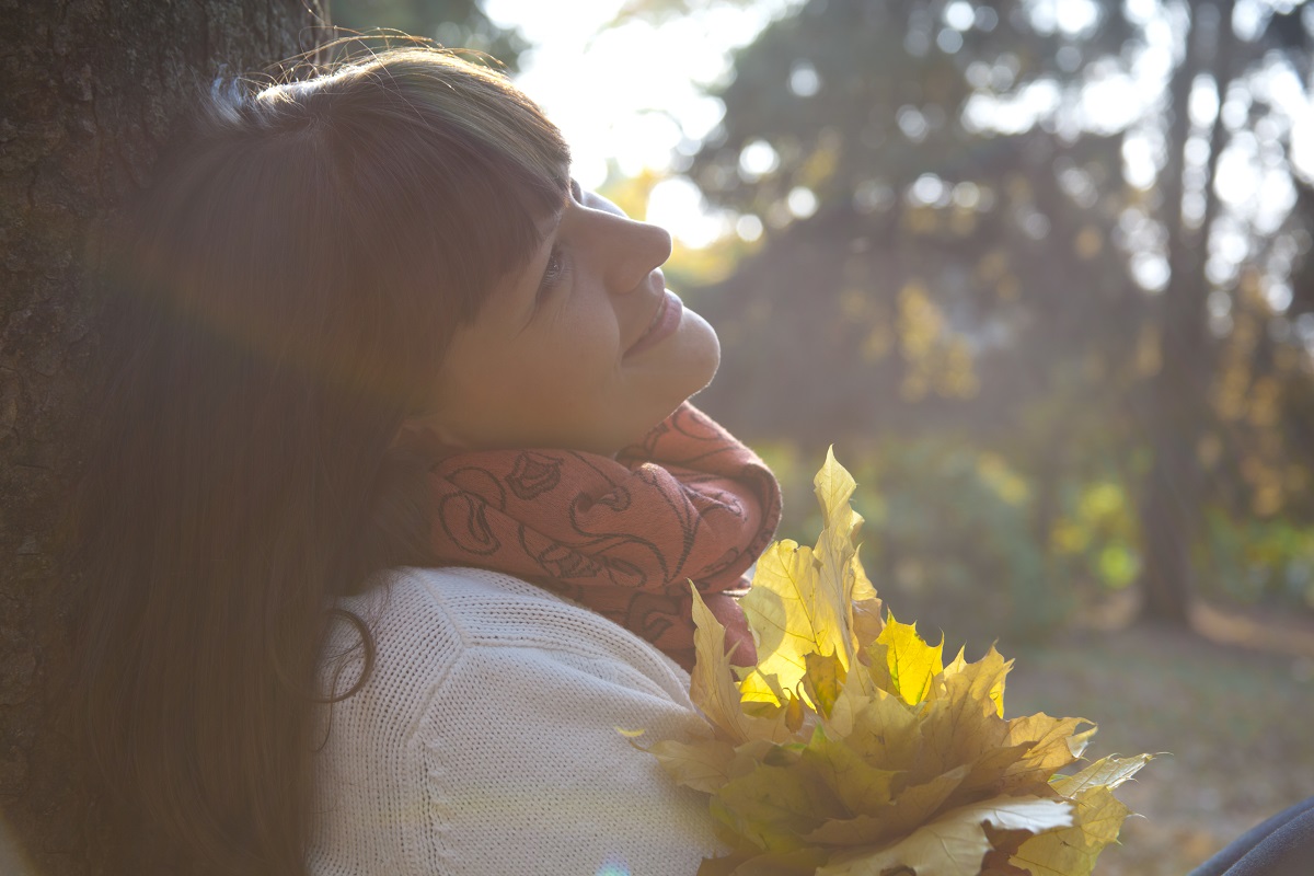 Woman enjoying nature with autumn leaves