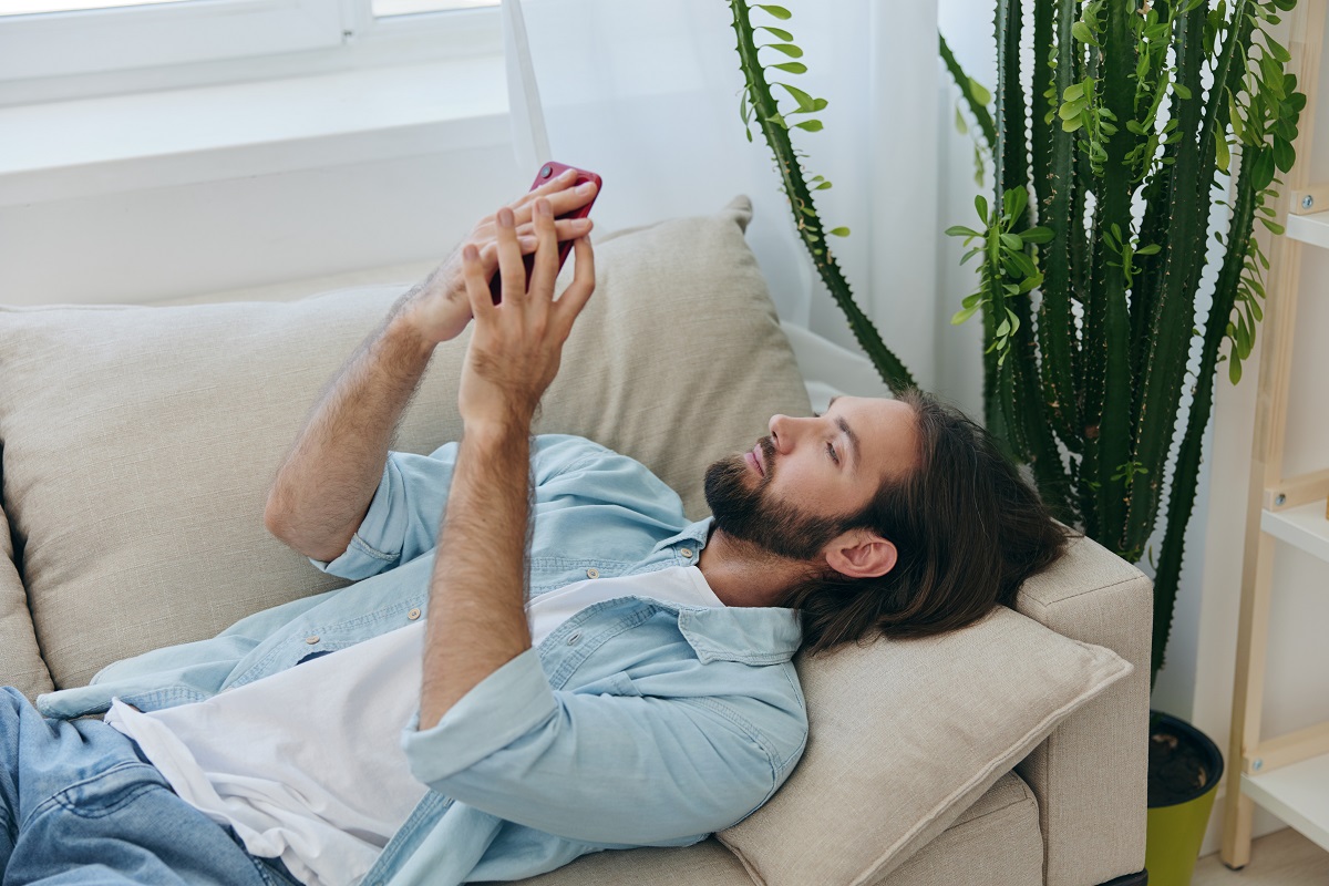 Man scrolling on phone at night.