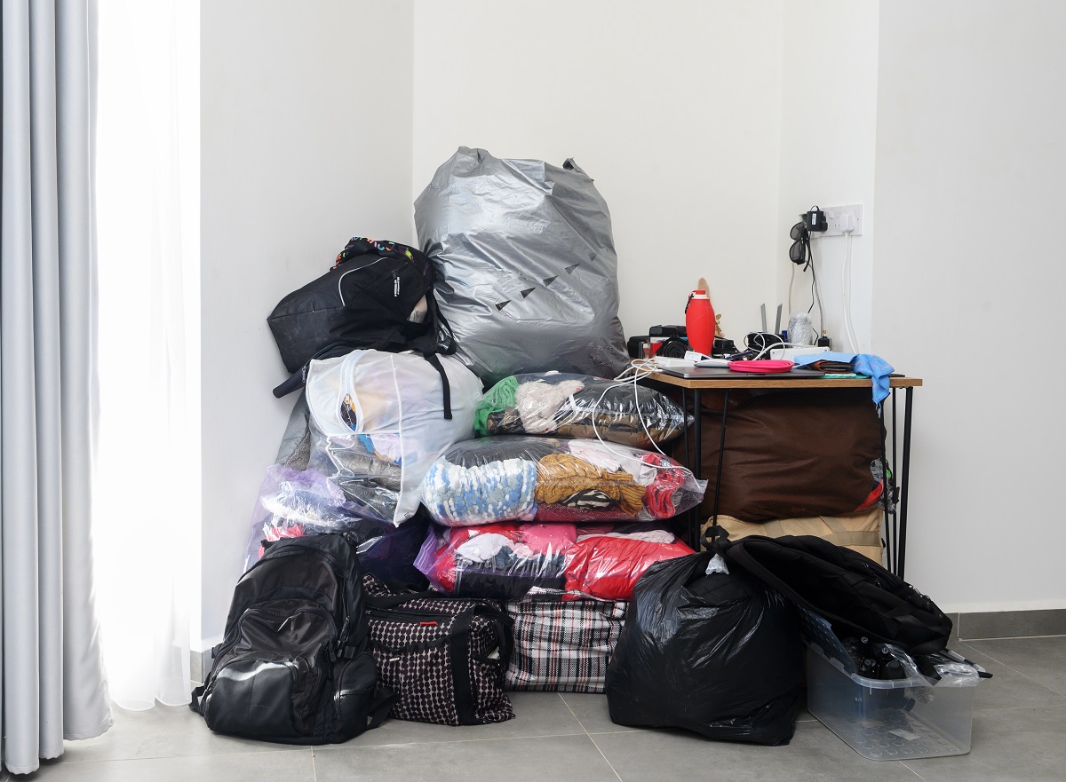 Bags and clutter stacked in a room