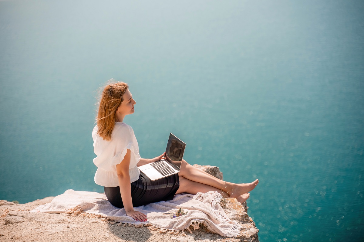 Woman working by the ocean.